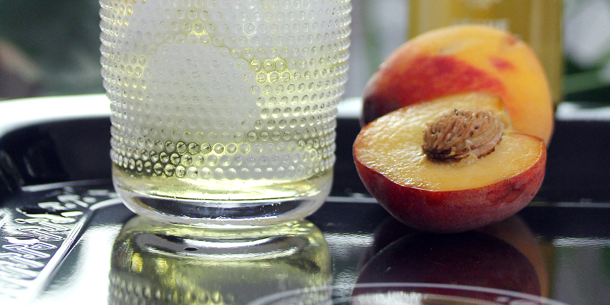 pêche coupée en deux et verre de jus de pêche glaçon