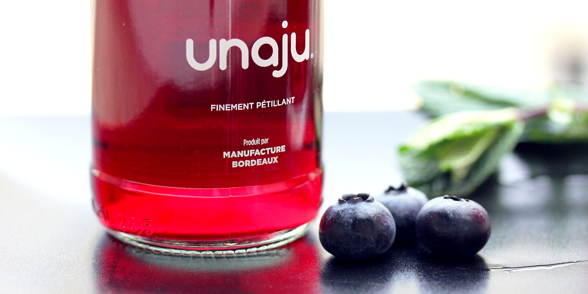 gros plan verre et bouteille de jus de cassis